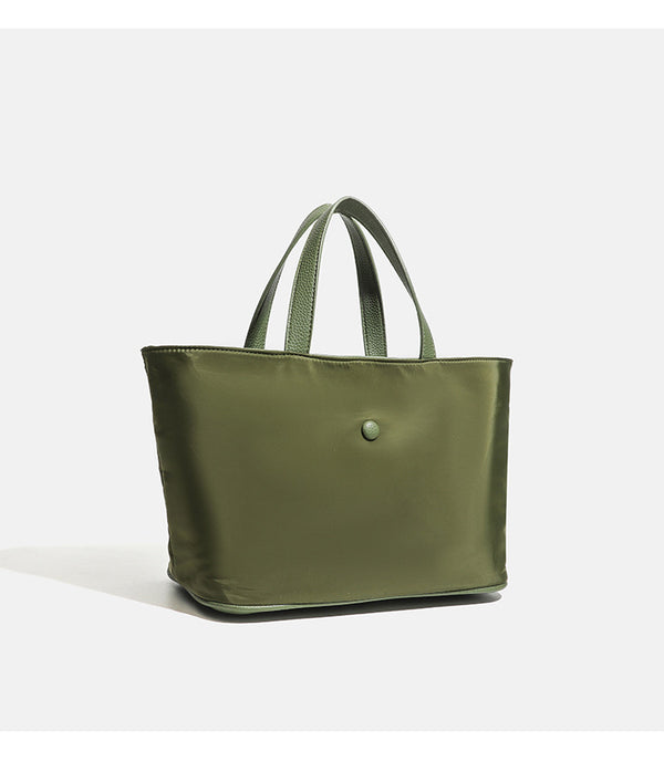 Structured lightweight nylon tote bag with textured double top handles and snap-button front detail, detail view 15