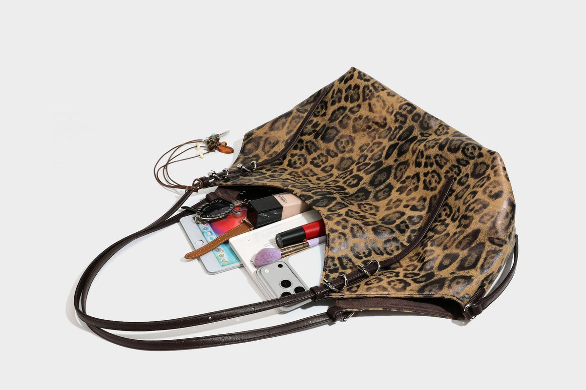 Slouchy leopard-print shoulder tote bag in tan and brown with long double straps, side tie straps, and dangling charm, detail