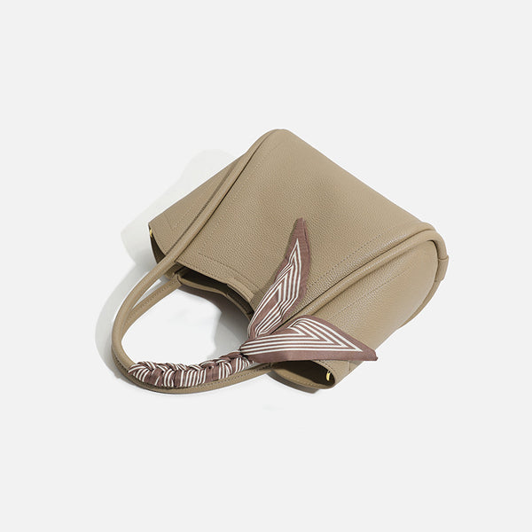 Pebbled leather-look bucket tote bag with scarf-wrapped top handle and gold-tone hardware, detail view 3