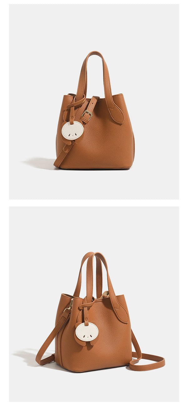 Pebbled leather-look bucket tote with elephant charm pendant, dual top handles, and detachable shoulder strap, detail view 10