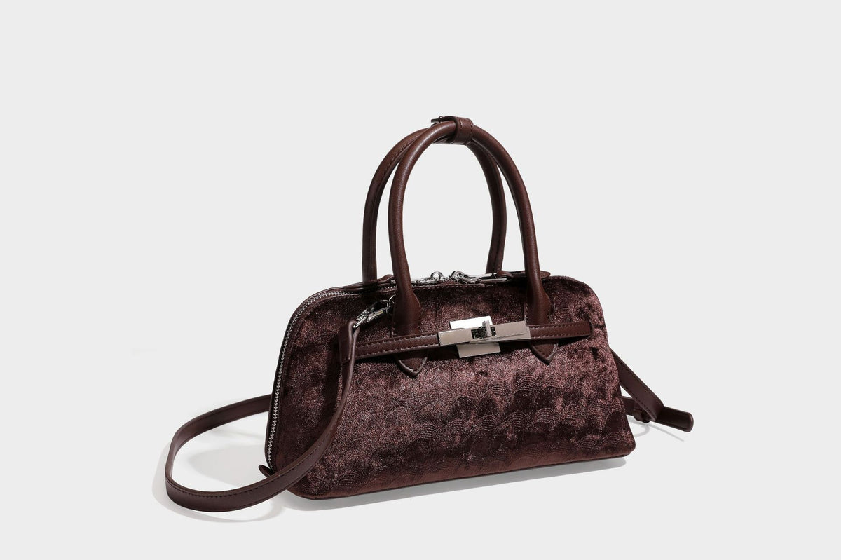 Small structured satchel bag in dark brown velvet-like textured finish with leather-look trim, silver-tone turn-lock bar