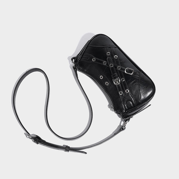 Compact moto-inspired shoulder bag with crisscross grommet strap detail, glossy textured finish, and adjustable crossbody