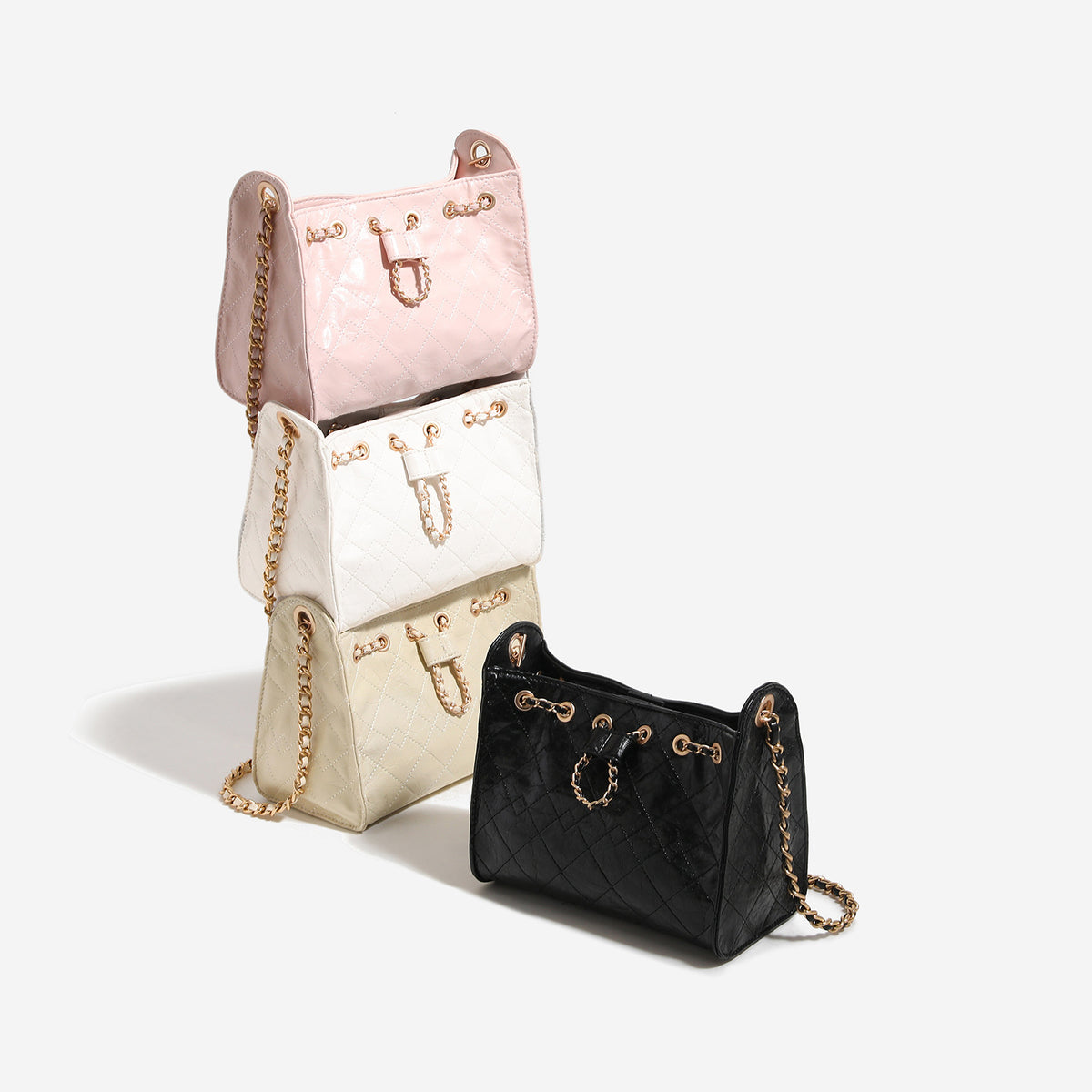 Glossy diamond-quilted drawstring bucket bag with gold-tone chain strap and eyelet hardware, detail view 2