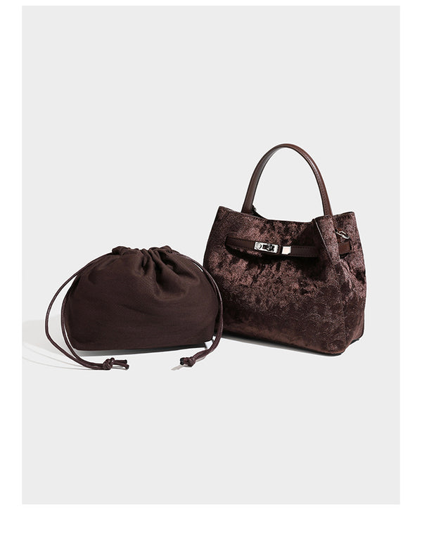 Small structured bucket satchel in embossed velvet-texture fabric with silver turn-lock hardware, rounded top handle, and
