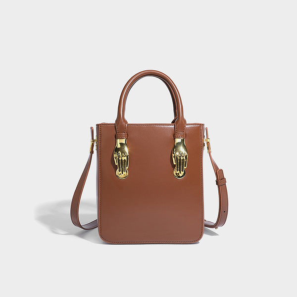 Kleine, strukturierte, kastenförmige Henkeltasche mit goldfarbenem, handförmigem Beschlag in schwarzer Lederoptik und abnehmbarem, Detailansicht