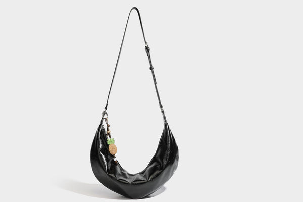 Legere, halbmondförmige Hobo-Schultertasche in glänzender, geknautschter Lederoptik mit schmalem Riemen, Ringbeschlägen in Silberoptik und