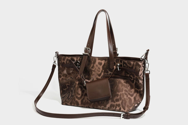 Glossy leopard-print tote bag with leather-look dark trim, dual top handles, detachable shoulder strap, and attached front
