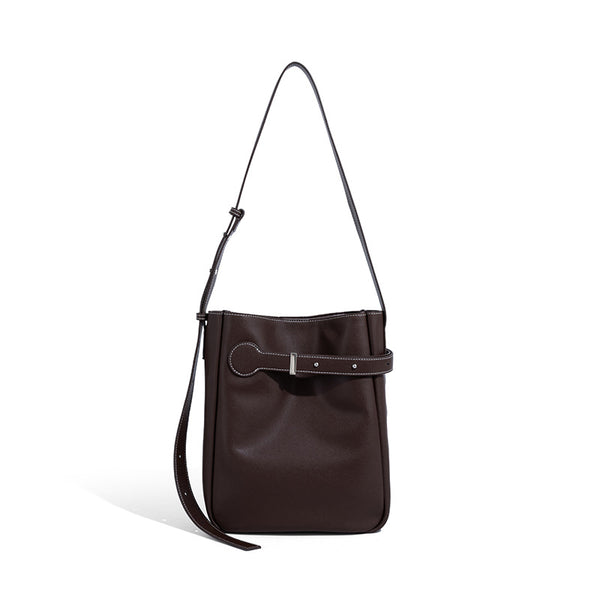 Structured dark brown leather-look bucket bag with white contrast stitching, front wraparound belt buckle strap, and long