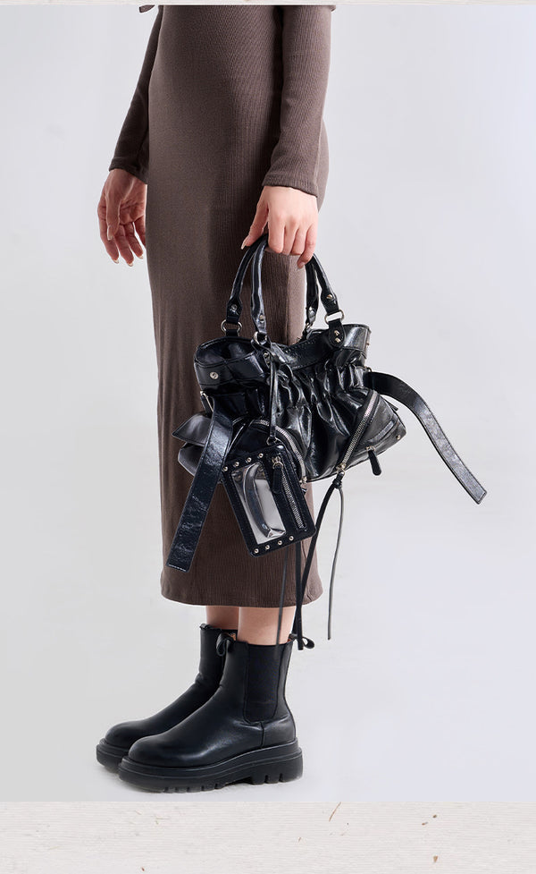 Black glossy ruched convertible tote bag with silver-tone rivets, detachable wide shoulder strap, external zip pouch, and