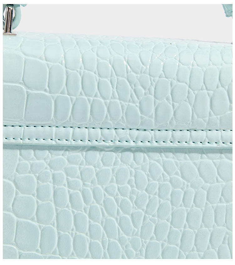 Small structured rectangular satchel with glossy crocodile-embossed finish, arched top handle, front flap, and silver-tone