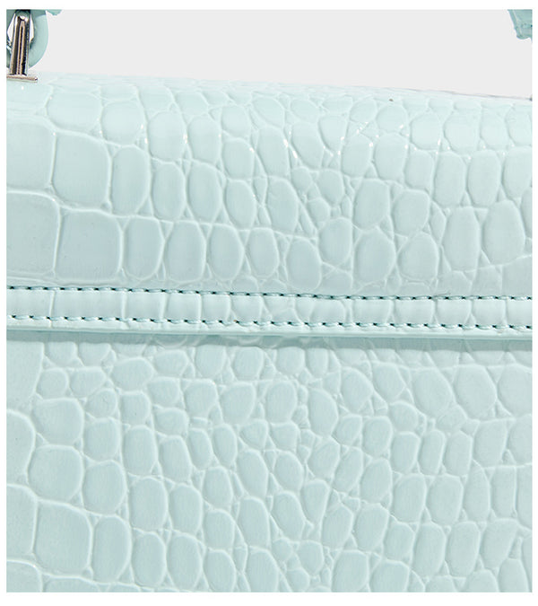 Small structured rectangular satchel with glossy crocodile-embossed finish, arched top handle, front flap, and silver-tone