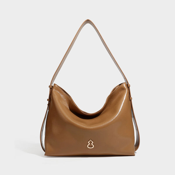 Lässig-sackförmige Hobo-Schultertasche mit offenem oberen Rand in glänzender karamellfarbener Lederoptik, goldfarbenen Logo-Beschlägen und langem verstellbarem