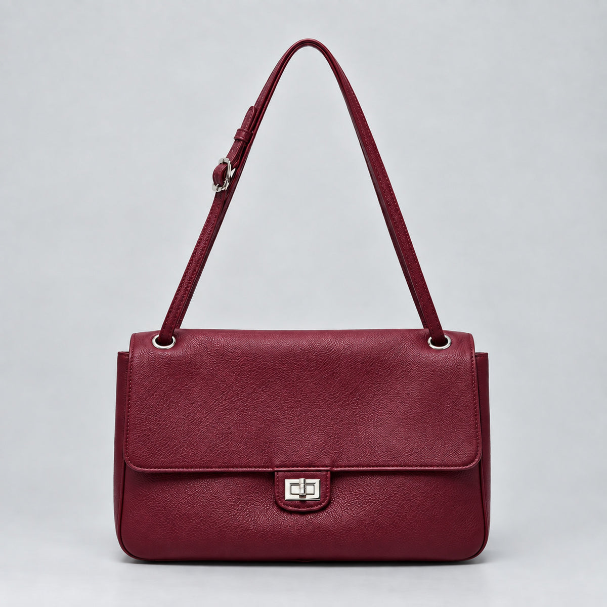 Structured black flap shoulder bag with pebbled texture, silver-tone turn-lock closure, and adjustable single shoulder strap