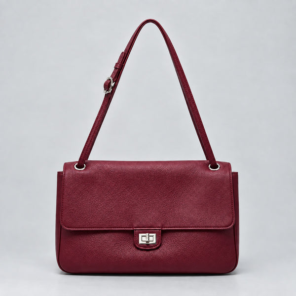 Structured black flap shoulder bag with pebbled texture, silver-tone turn-lock closure, and adjustable single shoulder strap