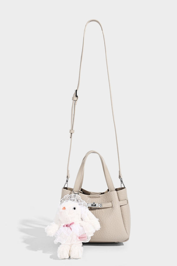 Small structured pebbled bucket tote with double top handles, silver turn-lock hardware, and detachable shoulder strap