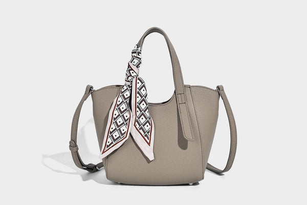 Structured pebbled leather-look tote bag with detachable scarf tie, dual top handles, and adjustable crossbody strap, detail