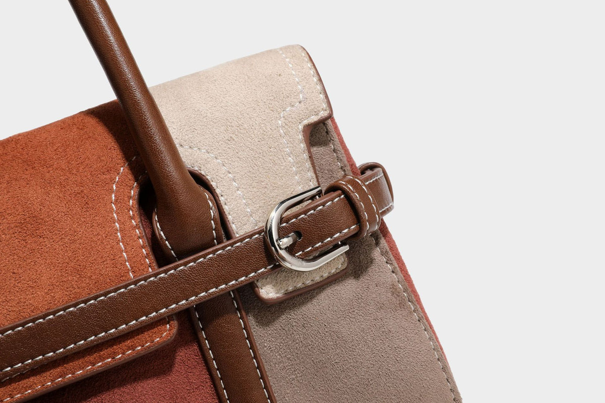 Structured color-block satchel bag in brown, rust, beige, and taupe suede-look panels with white topstitching, front buckle