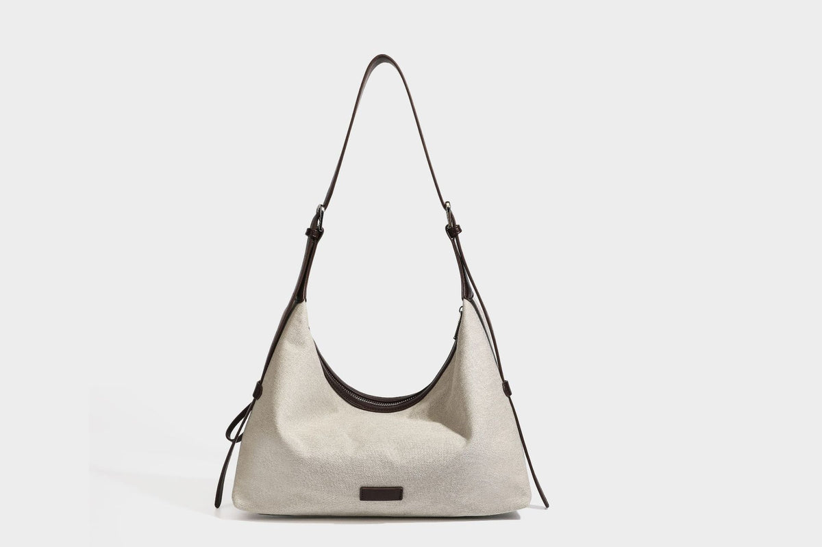 Lässige Hobo-Schultertasche aus haferfarbenem Canvas mit dunkelbraunen Besätzen in Lederoptik, silberfarbenem Reißverschluss und langem, verstellbarem