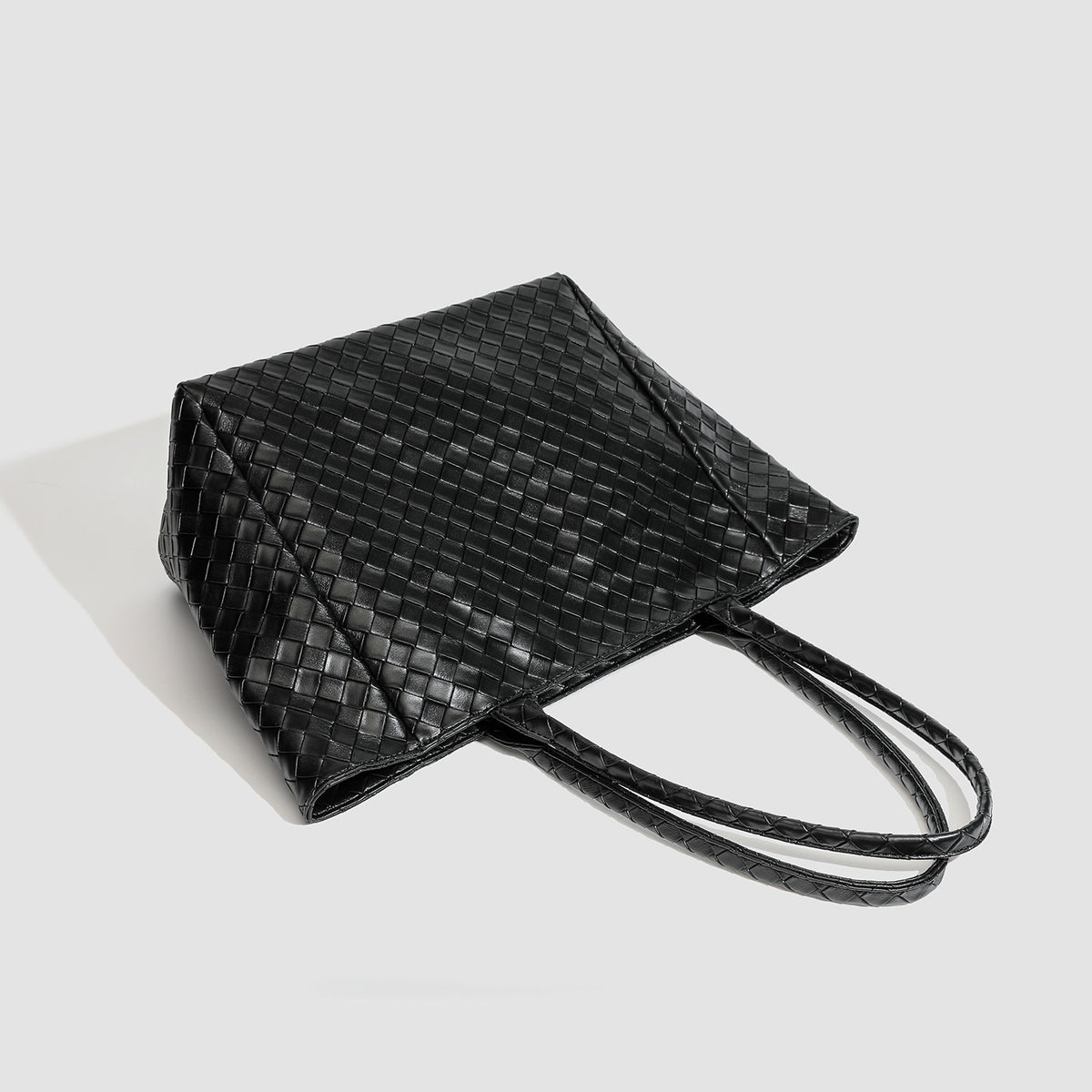 Large structured black woven diamond-pattern tote bag with braided double shoulder straps and glossy leather-look finish
