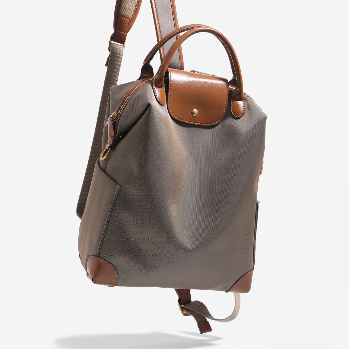 Large matte nylon backpack handbag with cognac leather-look trim, snap flap, and gold-tone hardware, detail view 2