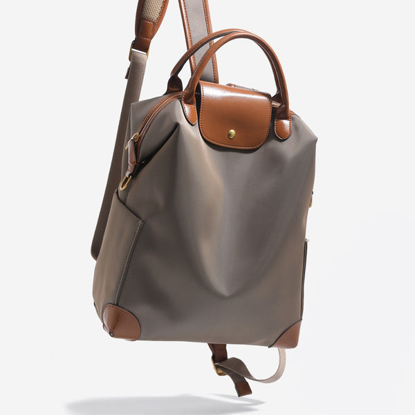Large matte nylon backpack handbag with cognac leather-look trim, snap flap, and gold-tone hardware, detail view 2