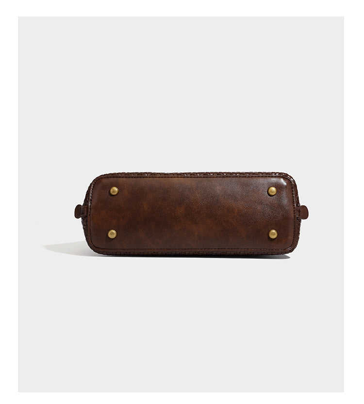 Structured woven-embossed leather-look satchel with dual rolled top handles, gold-tone turn-lock closure, and detachable