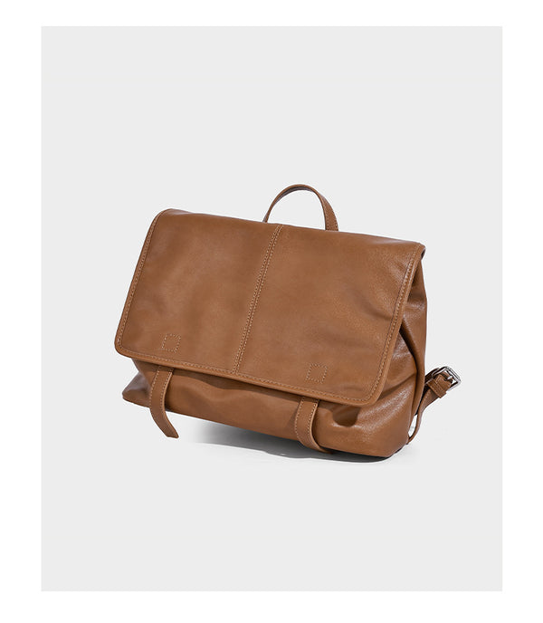 Structured tan leather-look flap backpack handbag with top handle, silver buckle hardware, and fold-over front closure