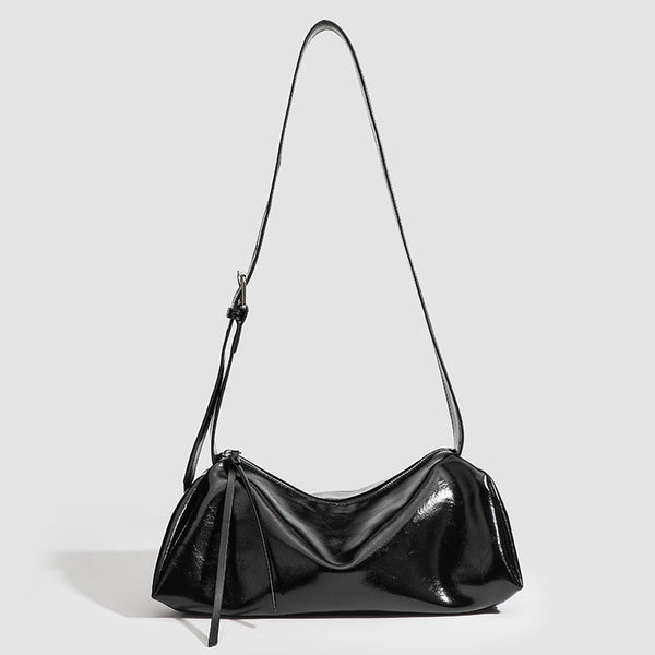 Black glossy leather-look slouchy shoulder bag with gathered top, zip tassel closure, and long adjustable silver-buckle