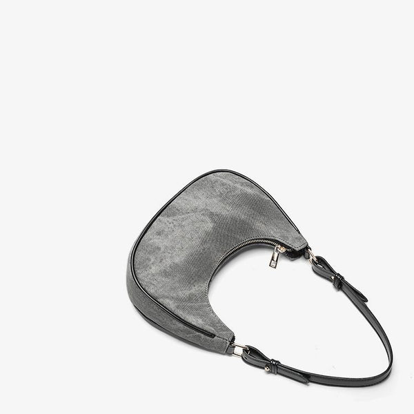 Small gray crescent half-moon shoulder bag with black leather-look trim, gold-tone zipper, and adjustable slim strap, detail