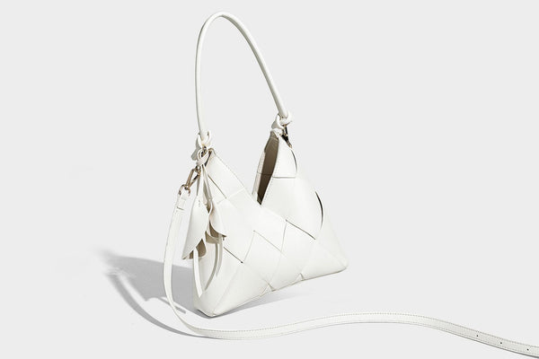 Compact bucket shoulder bag with black-and-white diamond patchwork panels, knotted top handle, gold-tone hardware, and