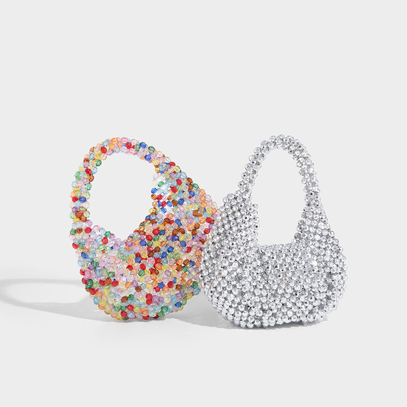 Small rounded hobo bag covered in faceted translucent crystal-look beads with a matching beaded top handle and silver, detail