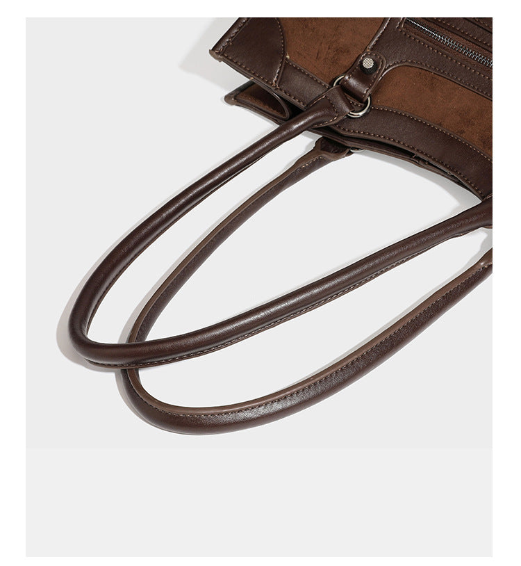 Large structured tote bag with matte suede-like body, smooth leather-look trim, front zip pocket, stud hardware, and