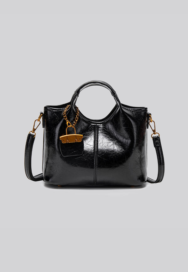 Structured crinkle-gloss top-handle satchel in deep burgundy with antique gold lock charm and detachable shoulder strap