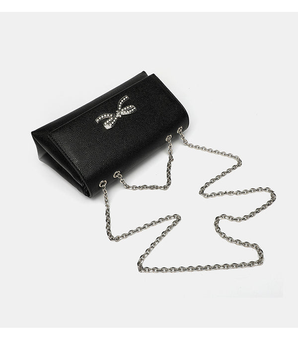 Structured rectangular flap crossbody bag with rhinestone bow and silver chain strap in pebbled finish, detail view 11