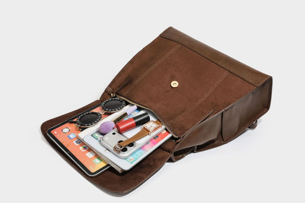 Structured suede-look convertible backpack handbag with flap closure and gold-tone emblem hardware in chocolate brown, detail