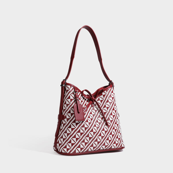 Woven geometric bucket shoulder bag in white and dark brown two-tone pattern with leather-look trim and drawstring top