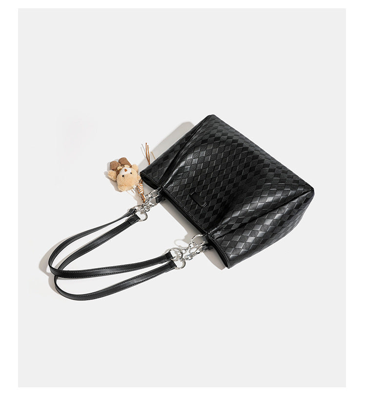 Black diamond-quilted leather-look tote bag with silver chain-ring shoulder straps and plush bear charm pendant, detail view
