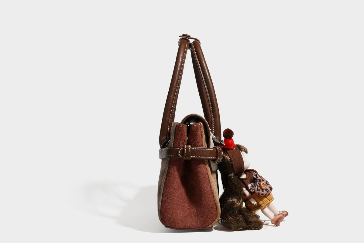 Structured color-block satchel bag in brown, rust, beige, and taupe suede-look panels with white topstitching, front buckle