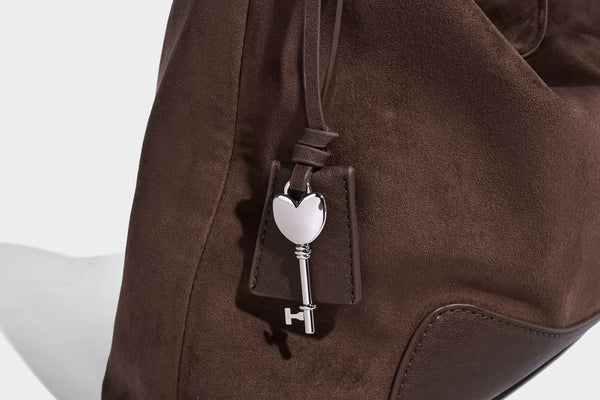 Dark brown slouchy hobo bag with matte suede-look body, smooth leather-look base trim, adjustable shoulder strap, and, detail