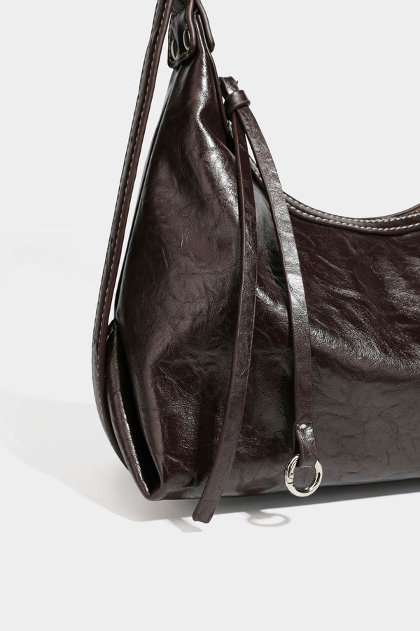 Slouchy hobo shoulder bag in glossy crinkled leather-look finish with zip-top closure and silver-tone ring hardware, detail