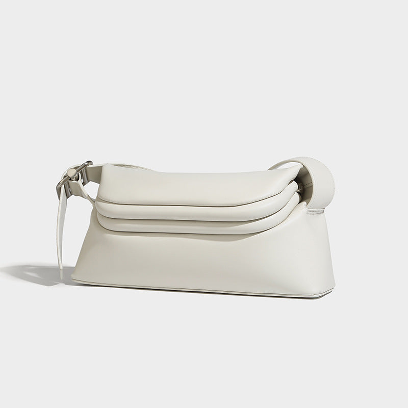 Compact structured baguette shoulder bag with smooth leather-look finish, zip top, and adjustable silver-buckle strap, detail