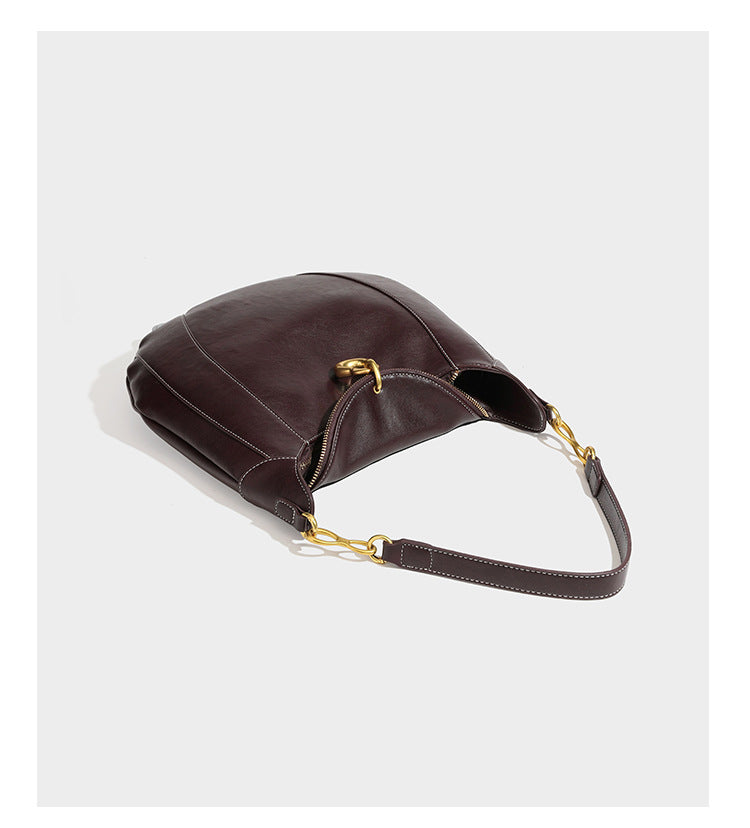 Locker fallende Hobo-Schultertasche in Halbmondform in Dunkelbraun mit goldfarbenem Ring und Kettenglied-Details sowie Reißverschluss oben, Detailansicht