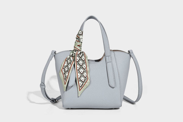 Structured pebbled leather-look tote bag with detachable scarf tie, dual top handles, and adjustable crossbody strap, detail