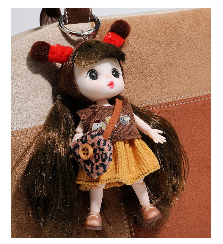 Boxy patchwork suede-look shoulder tote in tan, beige, rust, and brown panels with double brown straps and hanging doll