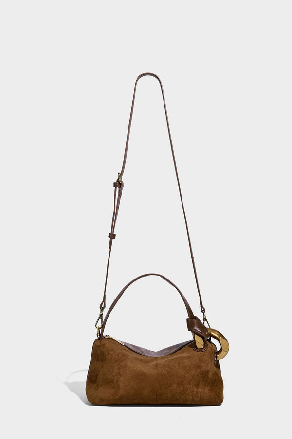 Kompakte Boston-Schultertasche in warmem Braun in Wildlederoptik mit glattem dunkelbraunem Besatz, übergroßen goldfarbenen Ringelementen und Reißverschluss oben
