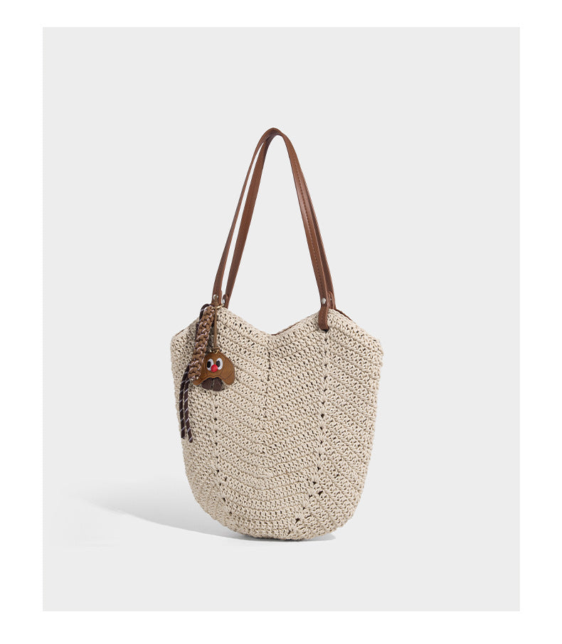 Woven crochet open-top shoulder tote bag with slim brown leather-look straps and braided charm accent, detail view 11