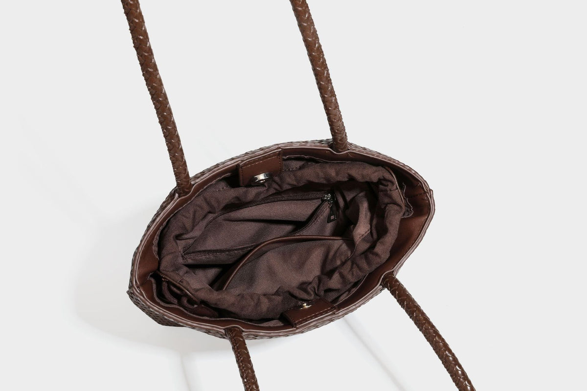 Structured woven leather-look tote bag in dark brown with long shoulder straps, side drawstring ties, and gold filigree