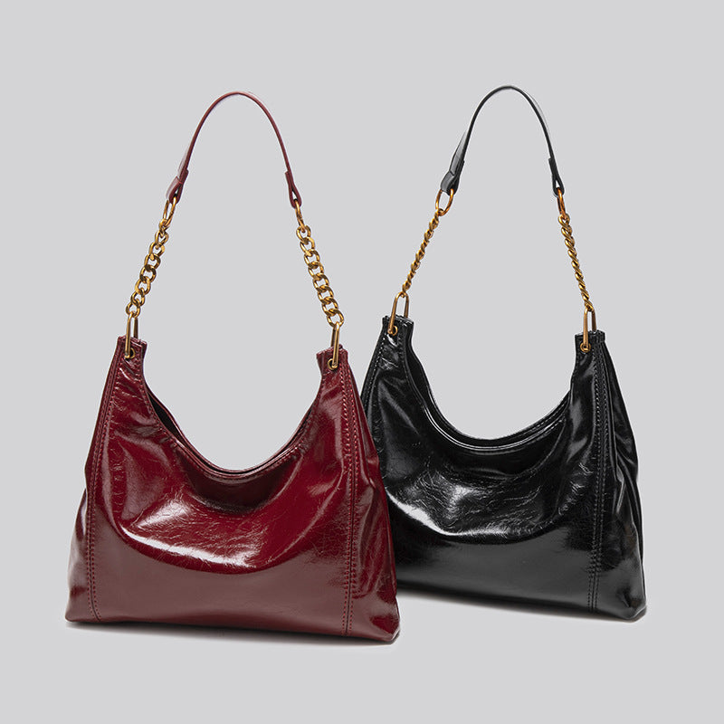 Glänzende Hobo-Schultertasche in Lederoptik mit Kettenriemen und Riemen aus Leder in Goldoptik, in tiefem Burgunderrot, Detailansicht 2