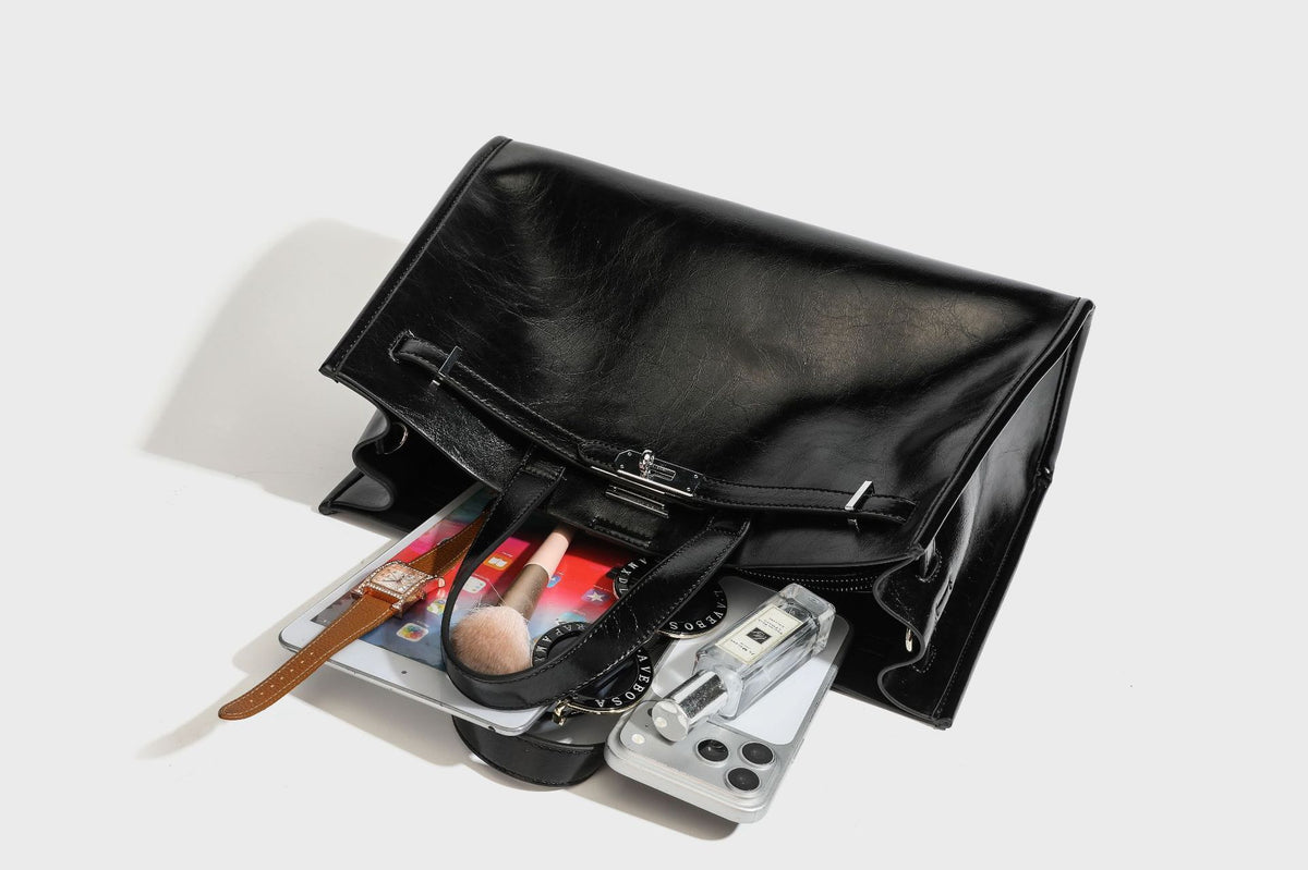 Strukturierter Shopper in glänzender Lederoptik mit silbernem Drehverschluss, zwei Henkeln und abnehmbarem Schulterriemen, Detailansicht