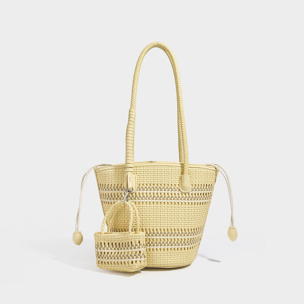 Structured woven bucket tote bag in pastel blue with braided shoulder strap, open lattice weave body, cream drawstring